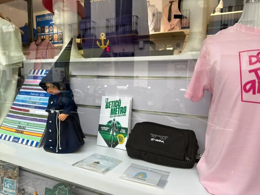 El libro El Beticómetro expuesto en el escaparate de De Triana, junto a camisetas y recuerdos de Triana